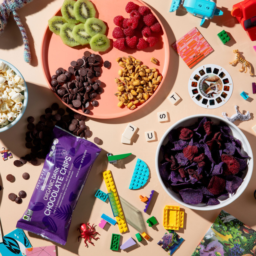 Organic dark chocolate chips with fruit, snacks, and colorful toys on a table