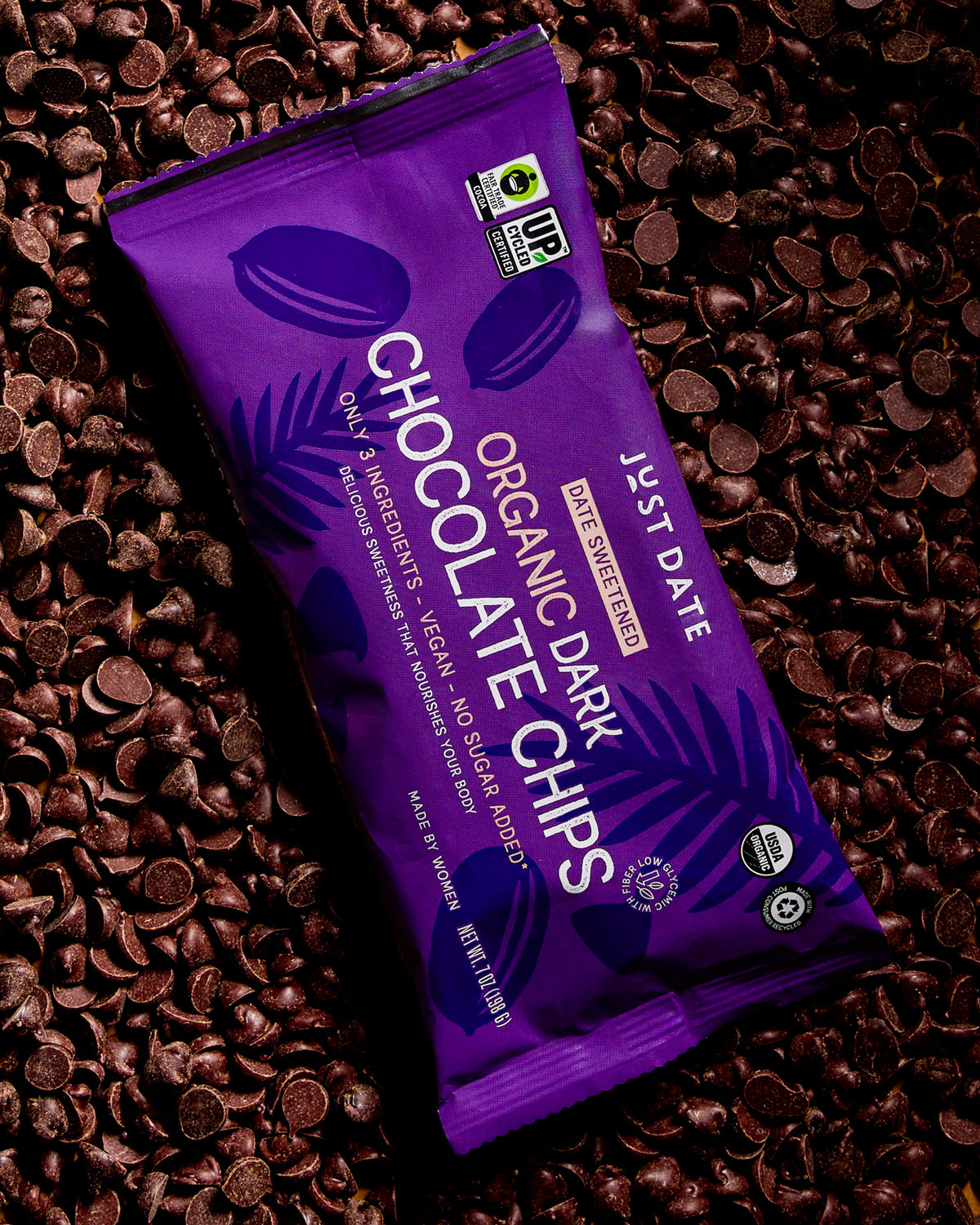 Purple package of organic dark chocolate chips on a bed of chocolate chips
